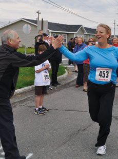 Newfoundland and Labrador Premier Kathy Dunderdale gives a high five to Grand Falls-Windsor / Green Bay South MHA Ray Hunter as she crosses the finish line at the 2011 Bell Aliant Photo by Reprinted with permission from The Telegram - thetelegram.com