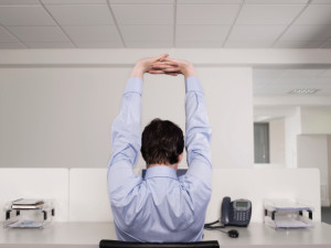 Male Office Worker Stretching At Desk