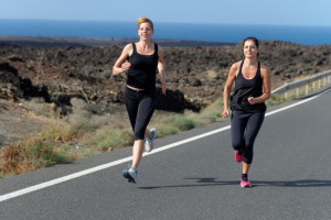 Two Runner women running on mountain road in beautiful nature