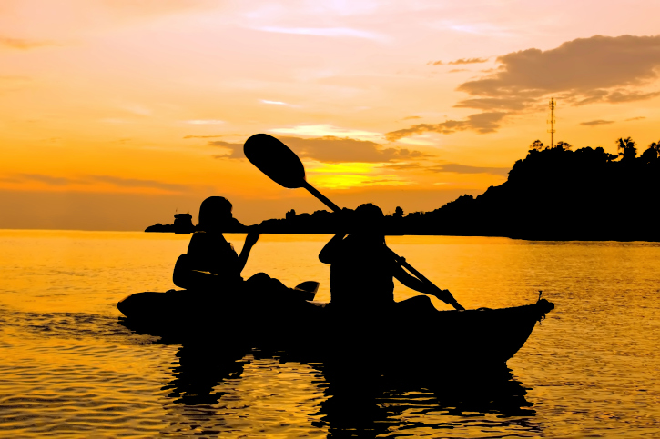 Silhouette of Two person kayaking in the sea