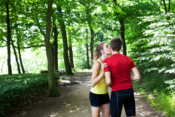 Kissing couple in a green forest