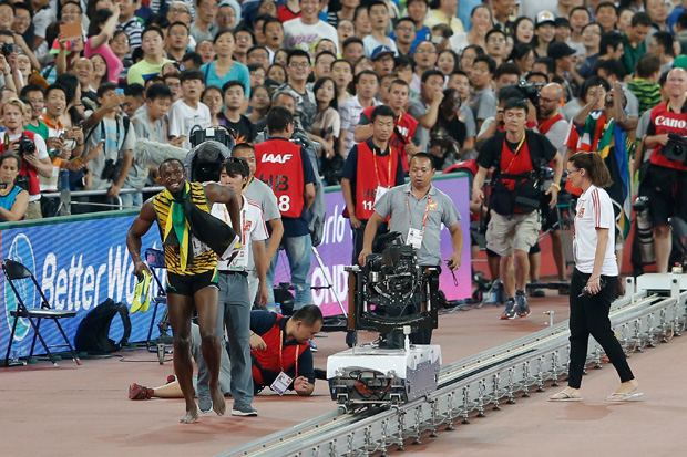 BEIJING, CHINA - AUGUST 27: A member of the media falls down in the melee as Usain Bolt of Jamaica celebrates after crossing the finish line to win gold in the Men's 200 metres final during day six of the 15th IAAF World Athletics Championships Beijing 2015 at Beijing National Stadium on August 27, 2015 in Beijing, China. (Photo by Lintao Zhang/Getty Images for IAAF)