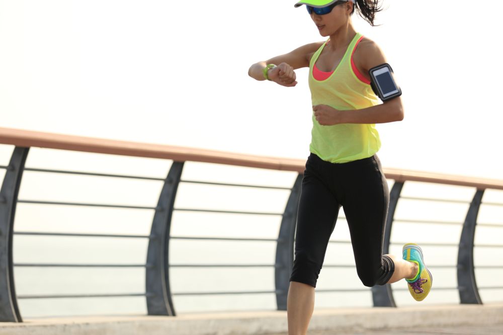 woman runner checking her running time from smart watch