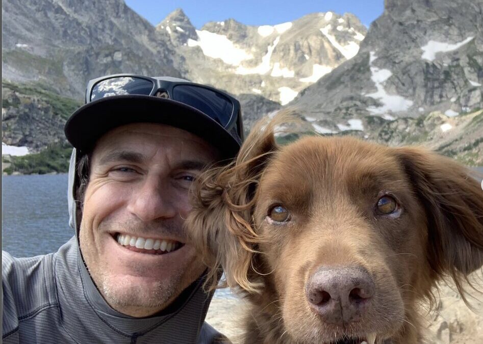 Brendan Leonard and his dog Rowlf in front of some mountains