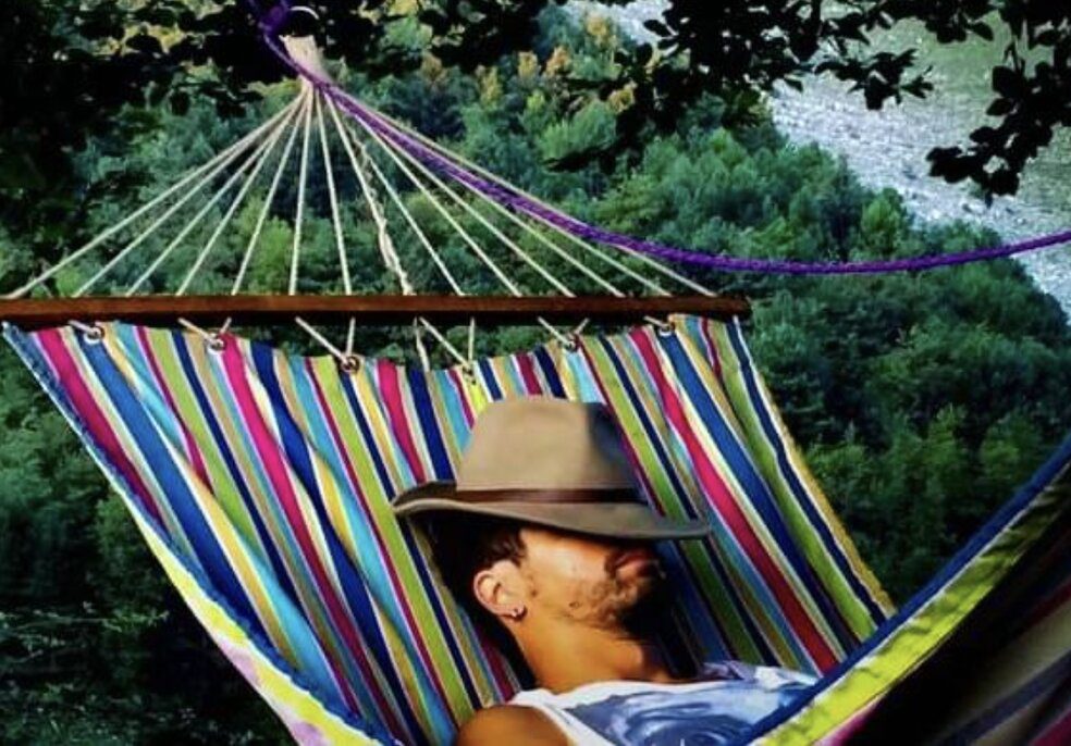 man napping in hammock with eyes closed