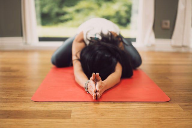 person on yoga mat in child's pose
