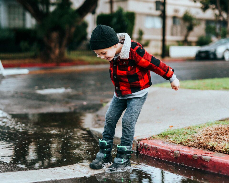 Child jumping in puddles