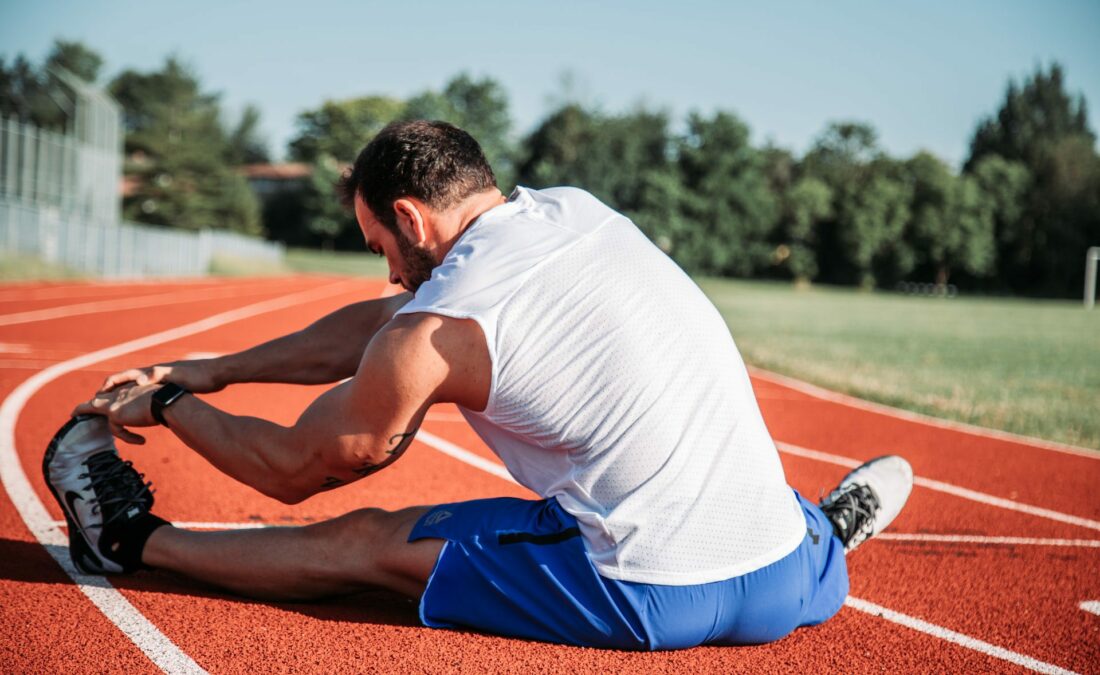 Runner stretching on track