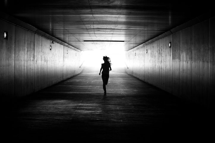 woman running into a dark tunne