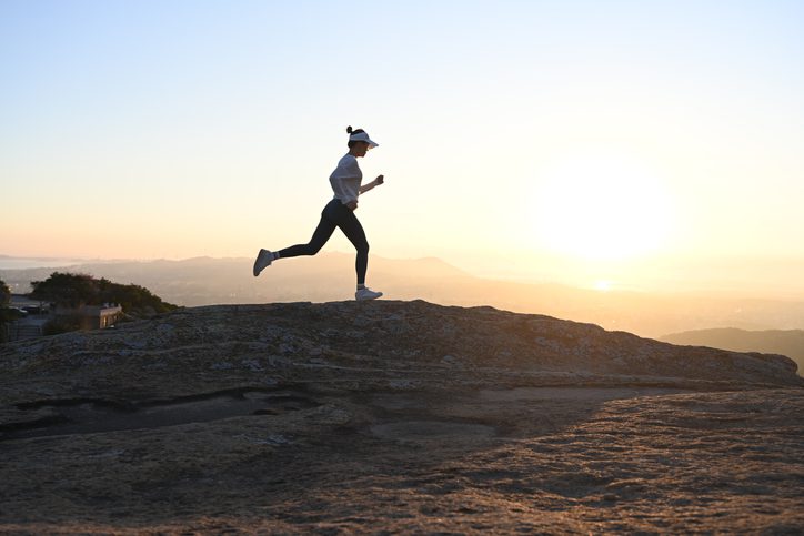 woman running on ridge at sunrise