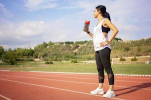 woman runner drinking water on track